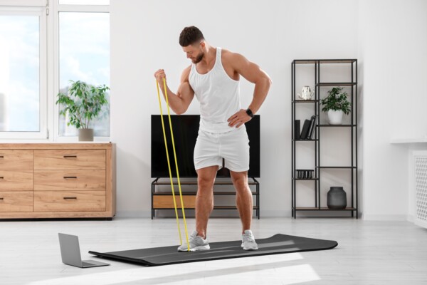 Muž posiluje biceps doma s odporovou gumou